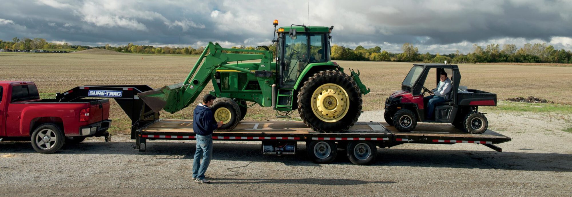 zoomed in side view of a tractor on the heavy duty low profile hydraulic beavertail deckover trailer