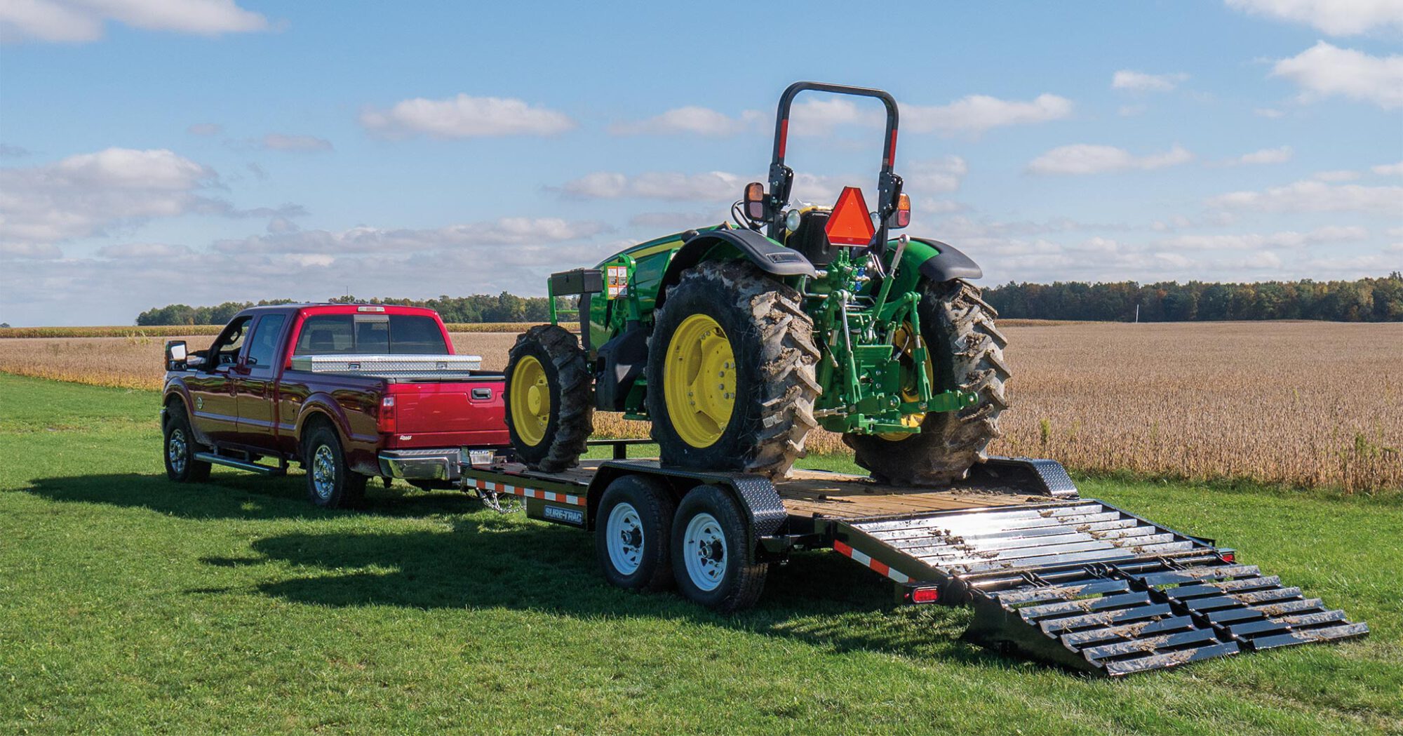 zoomed in view of the Universal Ramp Equipment Trailer with a tractor loaded onto it