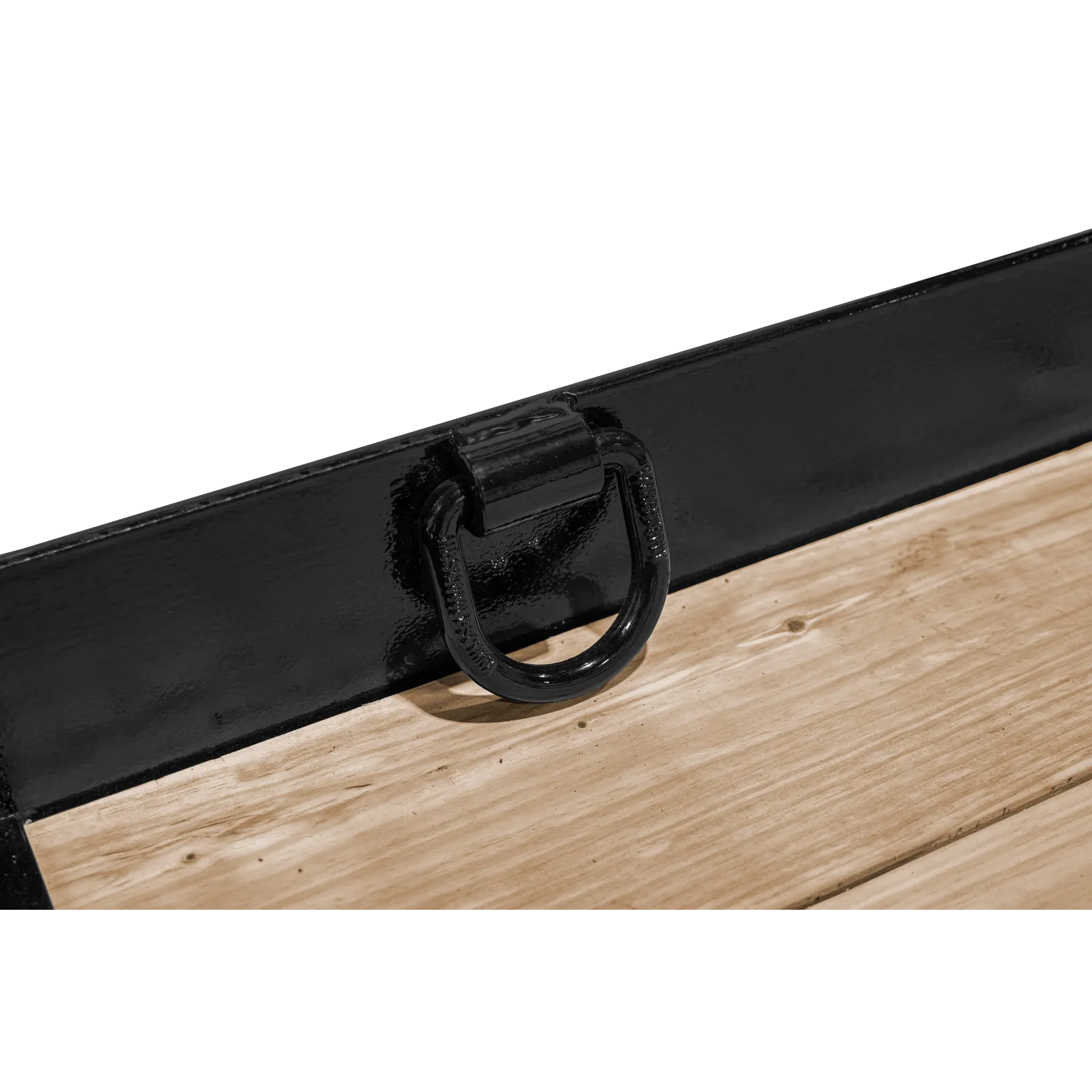 Close-up of a black metal latch and handle on a glossy toolbox resting on a wooden surface.