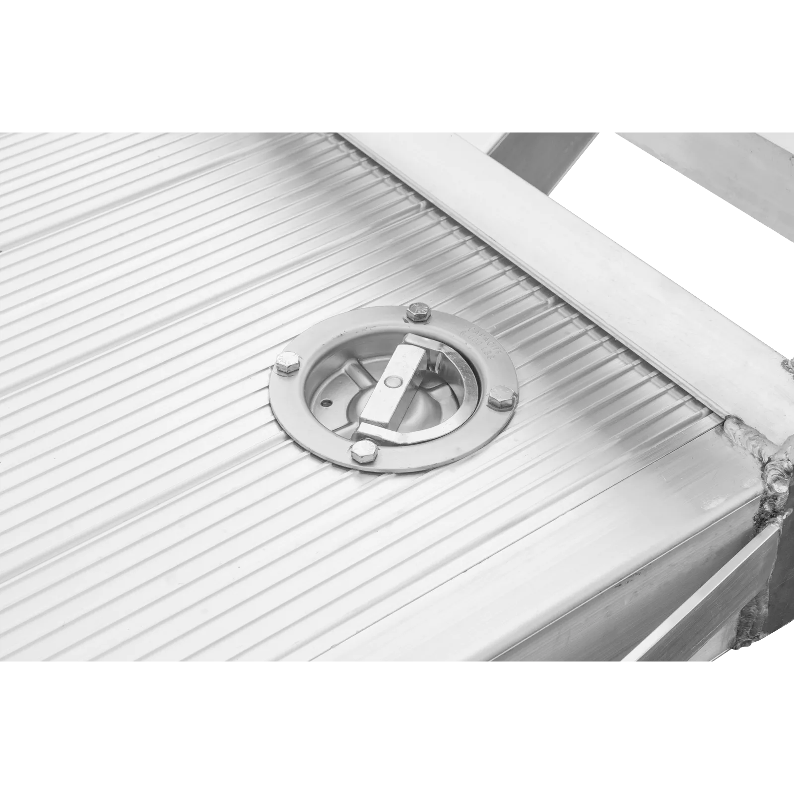 Close-up of a ribbed metal surface featuring a round bolted access hatch or vent in the center of the paneling.