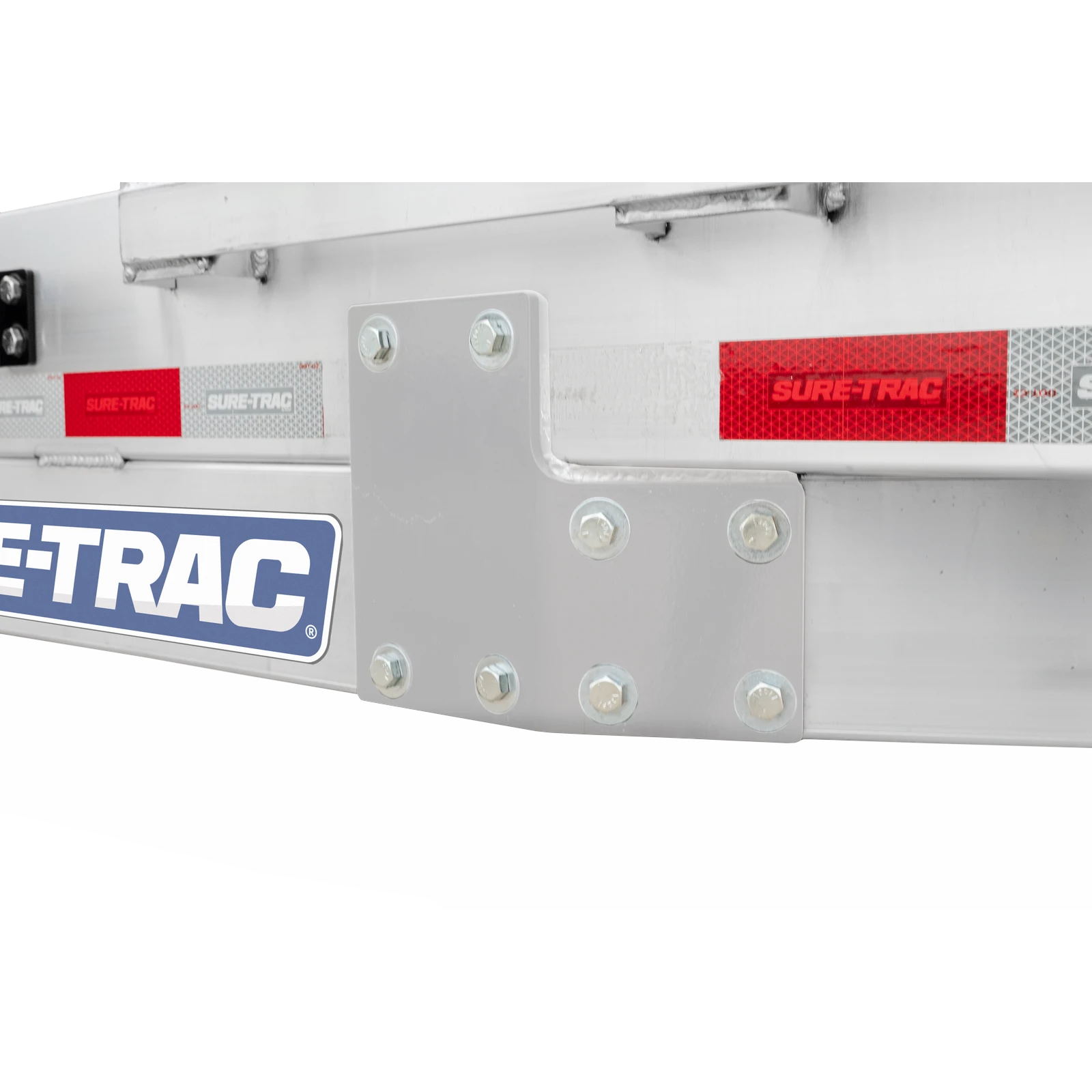 Close-up of a gray metal bracket with bolts on an industrial trailer component, with Sure-Trac branding visible.