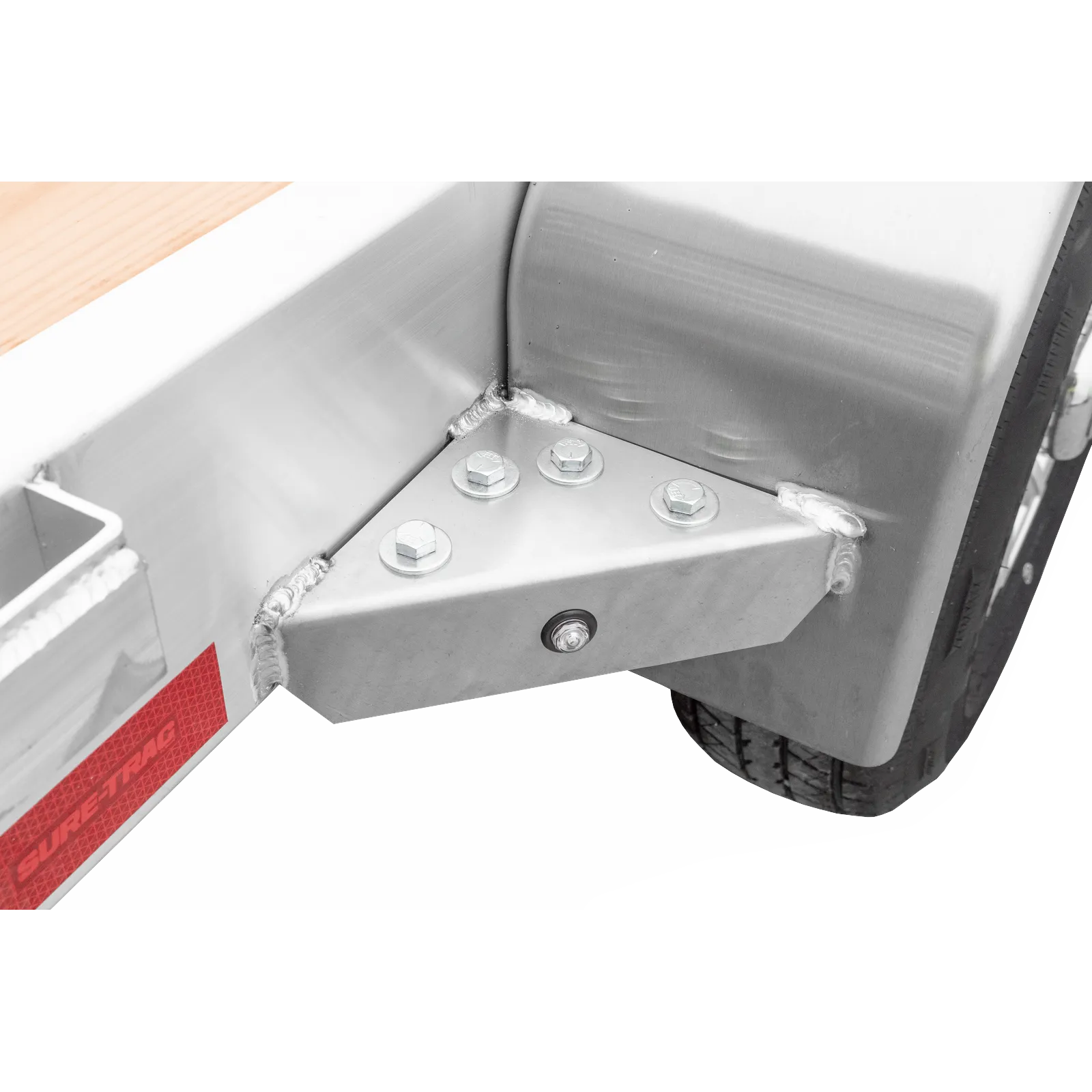Close-up of a metal frame joint with bolts and a wheel visible at the bottom right edge.