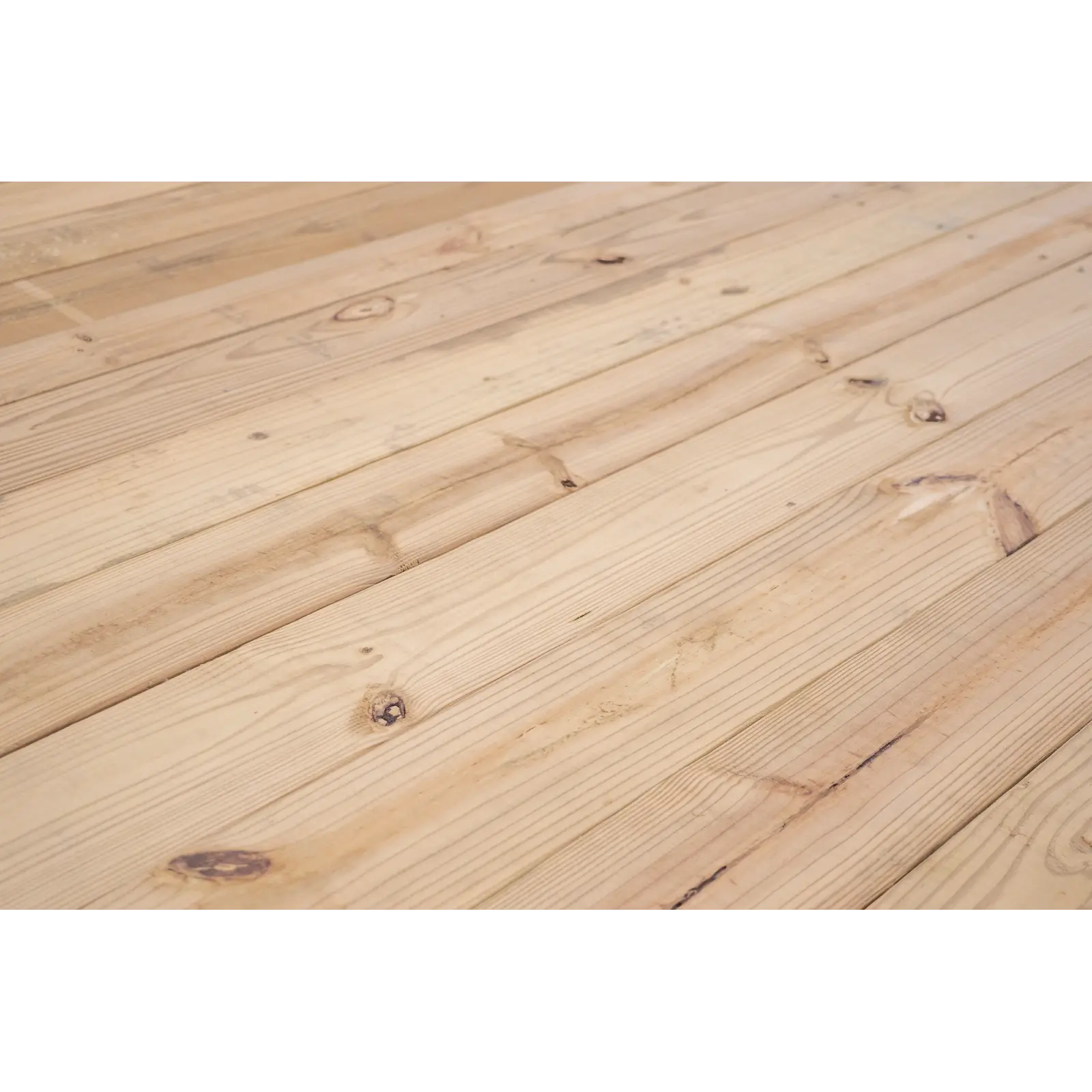 Close-up of light pine wooden floorboards with visible grain and knots throughout the planks.