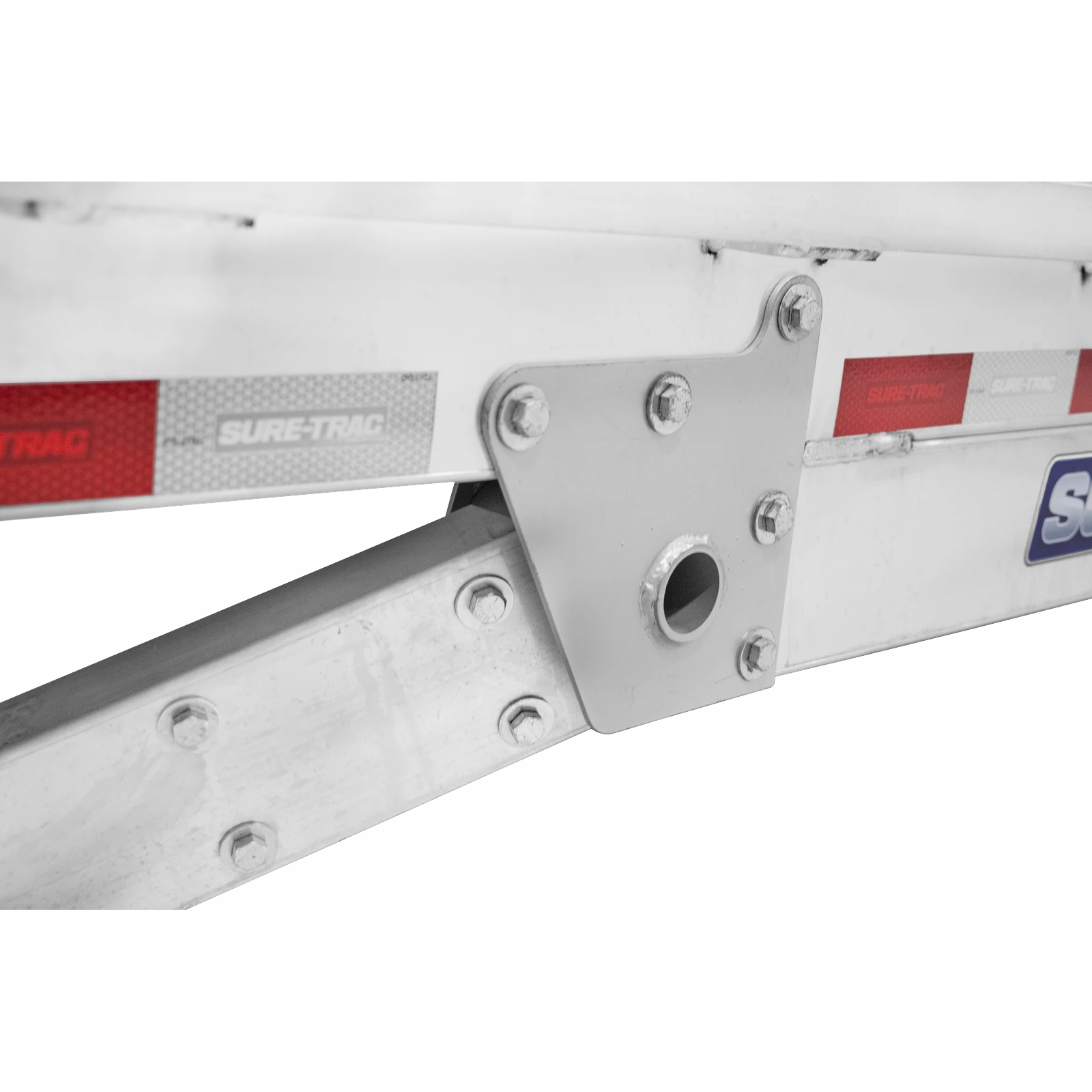 Close-up of a steel ladder beam bracket with bolts on a silver trailer, with Sure-Trac branding visible