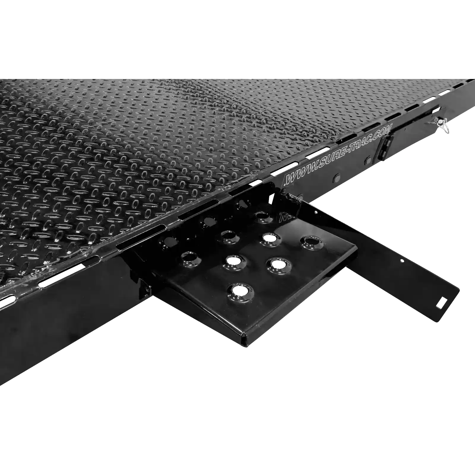 Close-up of a black diamond-plate trailer bed with holes and a side rail reading 'WWW.SURE-TRAC.COM'