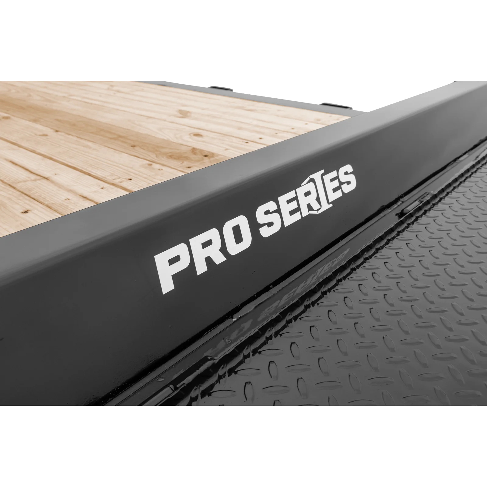Close-up of a gray metal edge with white 'PRO SERIES' lettering, adjacent to a diamond-plate ramp and wooden deck surface.