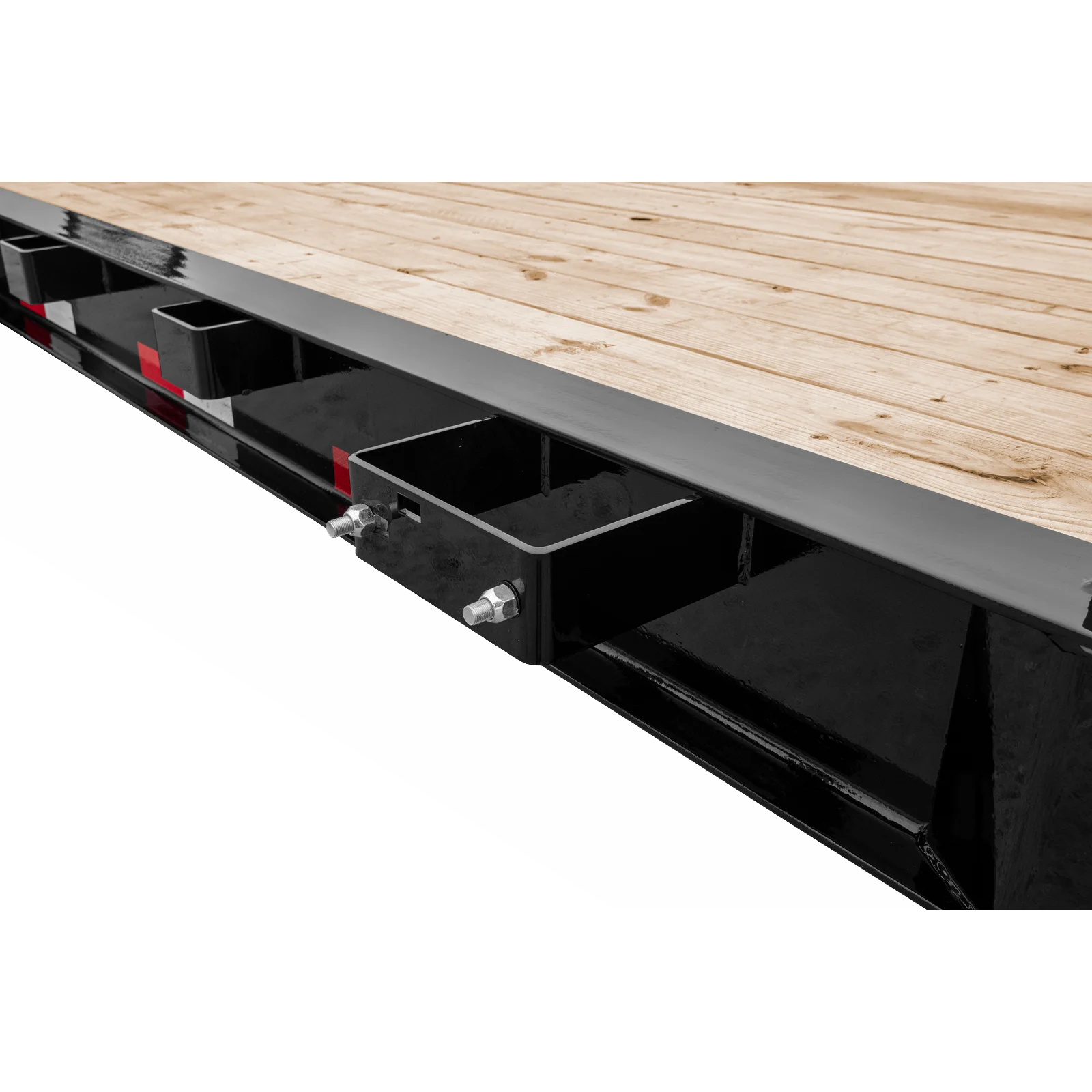 Close-up of a heavy-duty trailer deck: wooden planks atop a black steel frame with brackets and bolts
