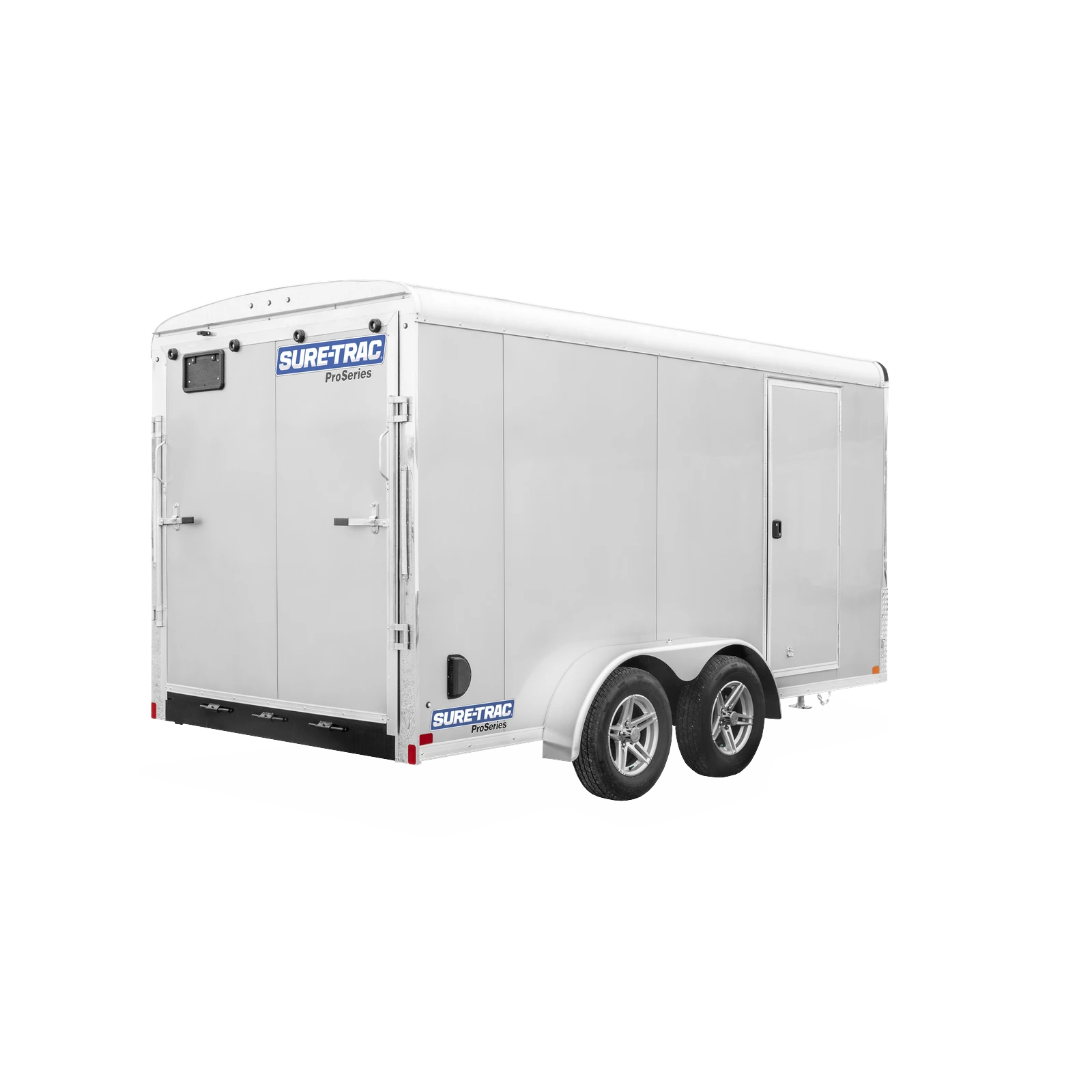 Silver enclosed cargo trailer with dual rear doors and Sure-Trac ProSeries logo, viewed from the rear-left side with dual axles and wheels visible