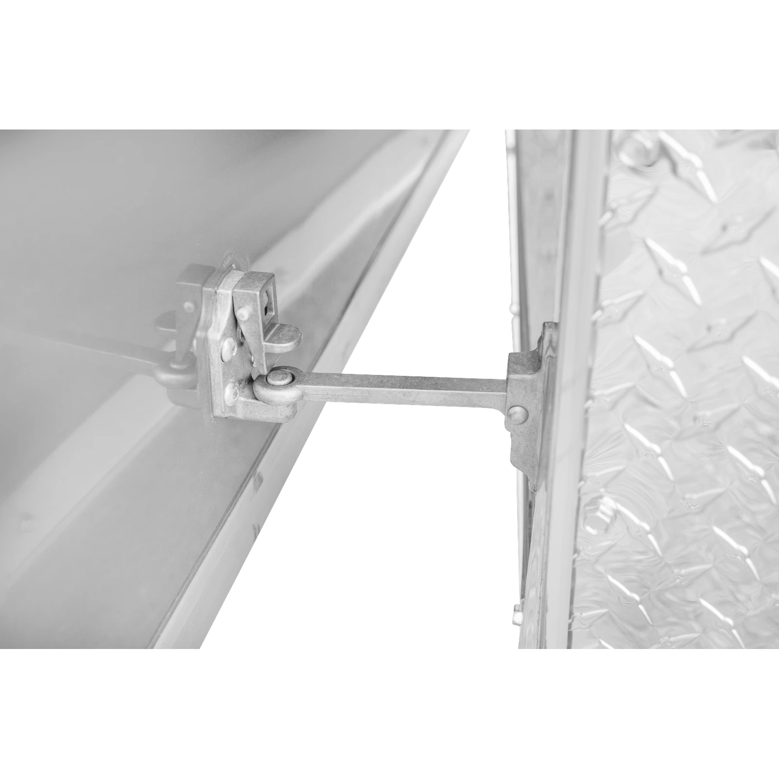 Close-up of a metal hinge and latch on a steel door, with diamond-plate texture visible on the right side.