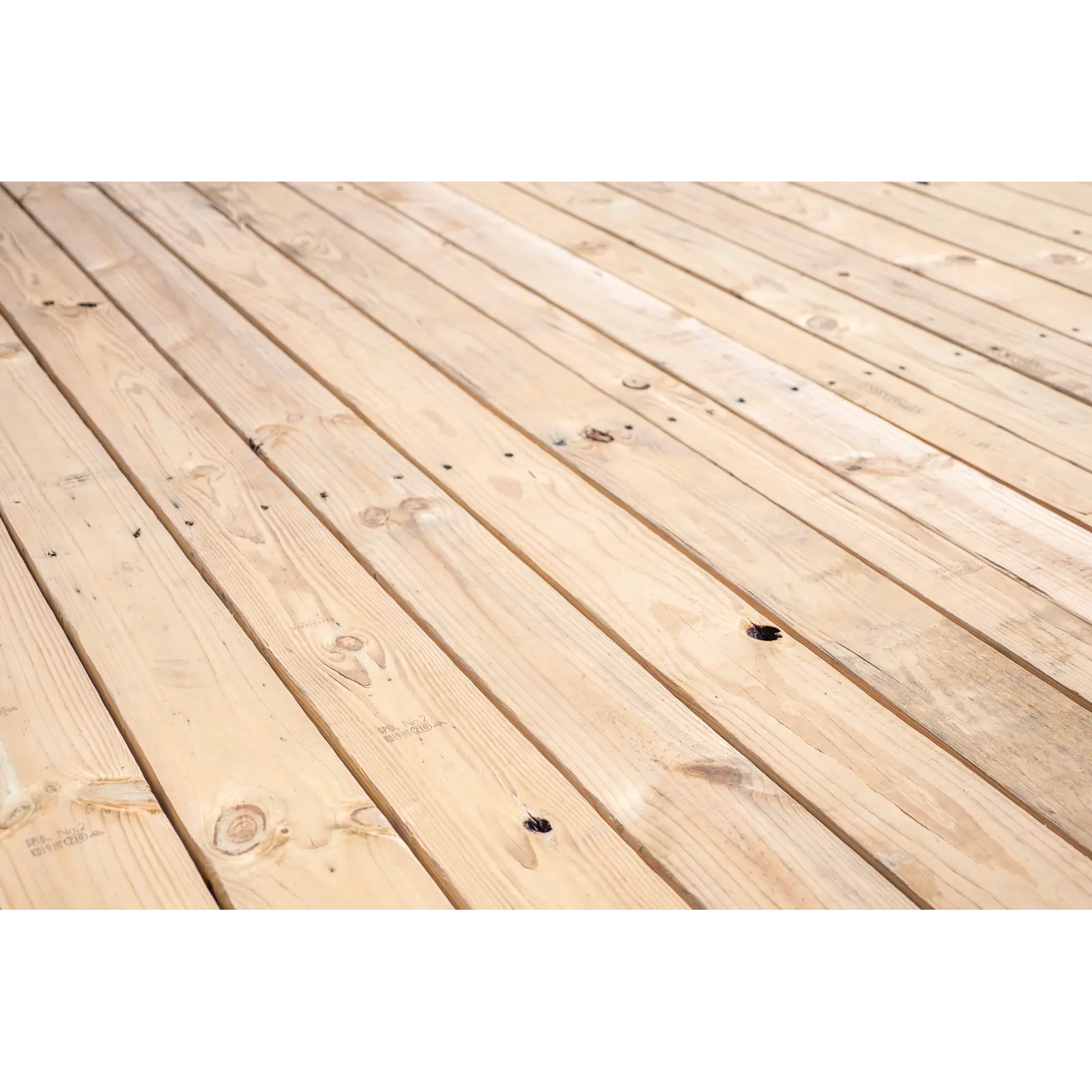 Close-up view of light wooden floorboards laid in parallel with visible grain and knots, seen from an angled perspective