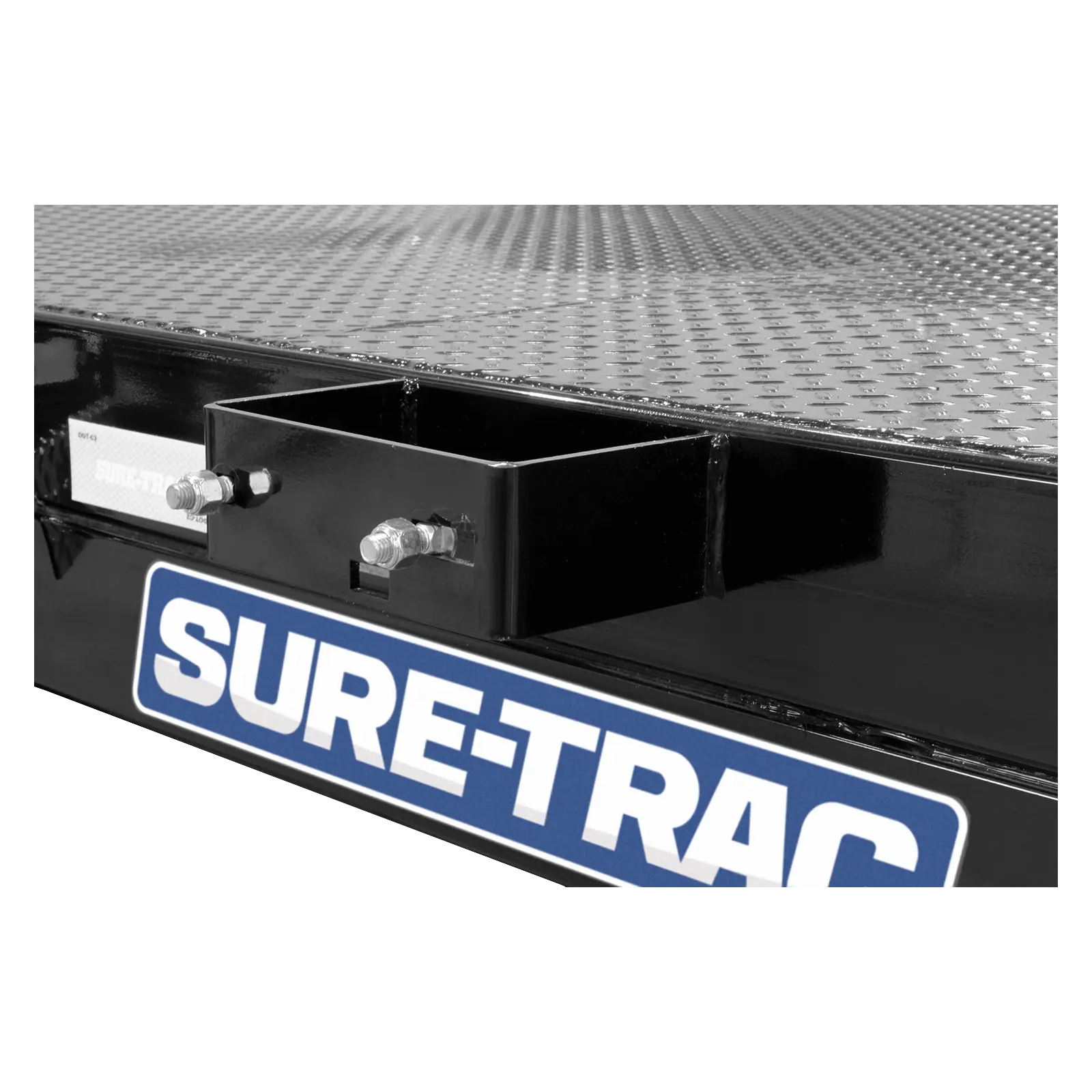 Close-up of a diamond-plate trailer bed with a black mounting bracket and a blue Sure-Trac logo plate.